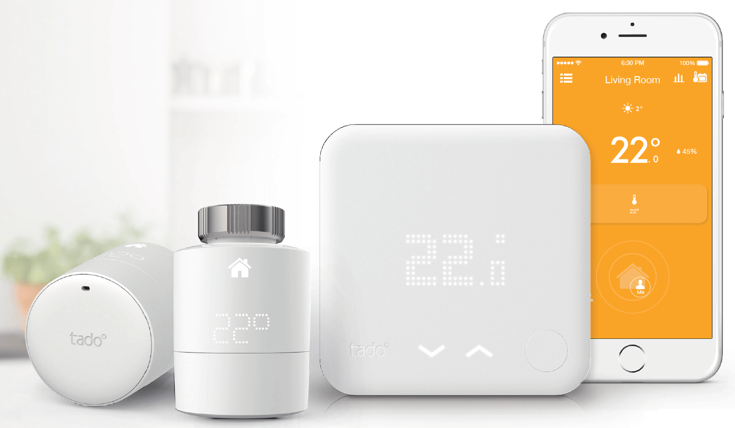 Tado thermostat along with its radiator and a smartphone with Tado app on the screen.