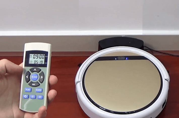 A robot vacuum and its remote control. 