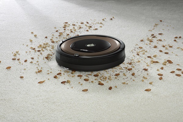 Roomba 980 navigating through debris on carpet.